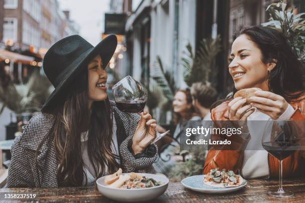 glückliche freunde, die tacos im freien in einem restaurant teilen - al fresco dining stock-fotos und bilder