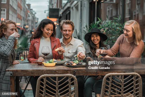 glückliche freunde, die tacos im freien in einem restaurant teilen - al fresco dining stock-fotos und bilder