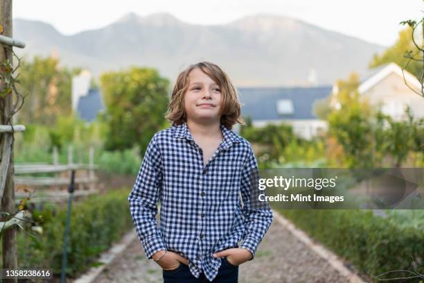 portrait of eight year old boy smiling, hands in his pockets. - 7 stockfoto's en -beelden