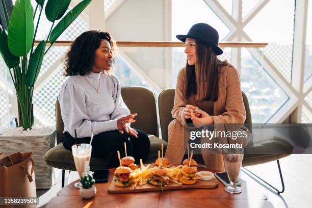 before they start having lunch, best friends chat casually in a fast food restaurant. - blended coffee drink stock pictures, royalty-free photos & images