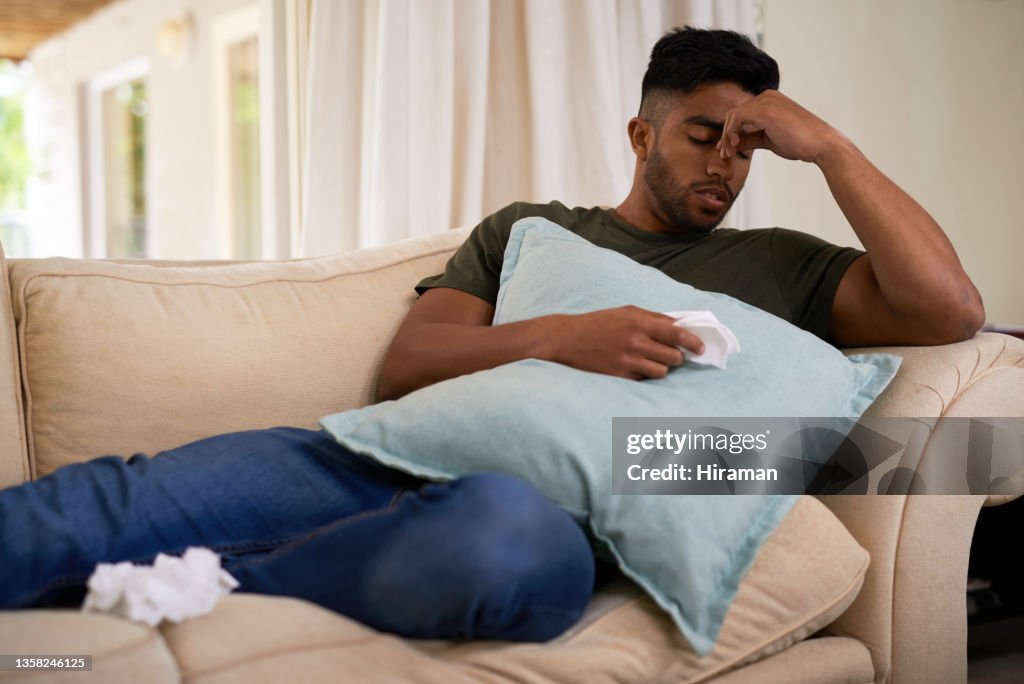 Shot of a young man suffering from a cold at home