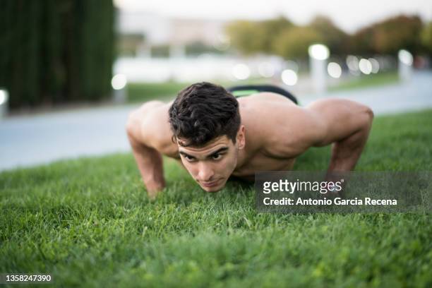 man training fotness and running in public city park - brustmuskulatur stock-fotos und bilder
