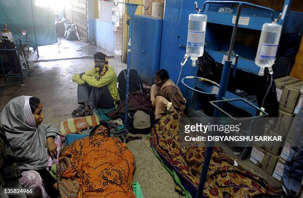 Relatives and victims receive medical treatment at the Diamond Harbour hospital in Diamond Harbour, after dozens died and many injured drinking...