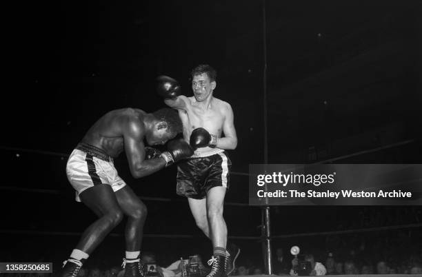 Ezzard Charles ducks below a right jab from Cesar Brion during their Heavyweight bout in Madison Square Garden, New York, New York, October 24, 1952....