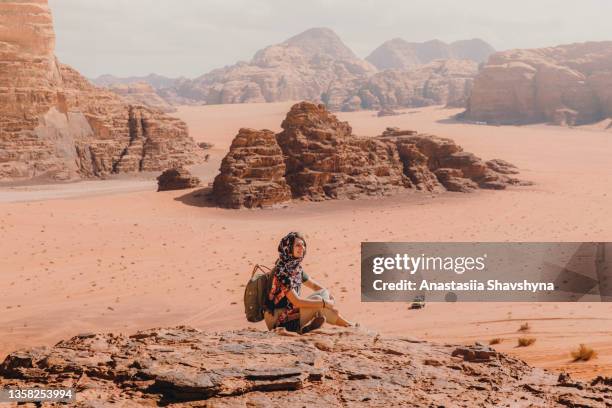 reisende, die den malerischen bergblick auf die wüste wadi rum von oben betrachtet - hot arab women stock-fotos und bilder