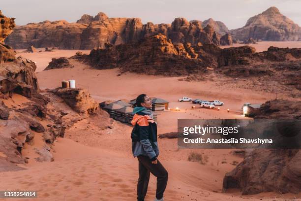 woman traveler walking to the bedouin camp hidden in the rocks of wadi rum desert during twilight - hot arabian women stock pictures, royalty-free photos & images