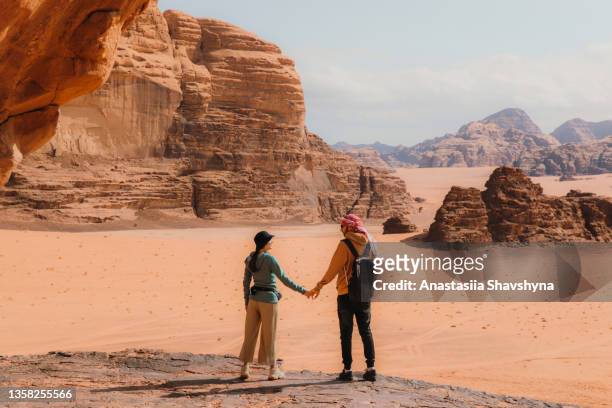 jovem mulher e homem viajante contemplando a paisagem cênica do deserto de wadi rum - hot arab women - fotografias e filmes do acervo