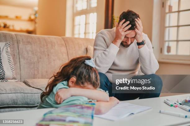 shot of a father and daughter looking frustrated while completing homework together at home - frustrated parent stock pictures, royalty-free photos & images