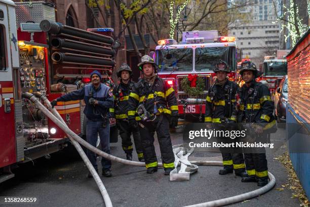 Firefighters watch a 4-alarm fire in a residential building on Montague Street December 10, 2021 in the Brooklyn borough of New York City. Four...