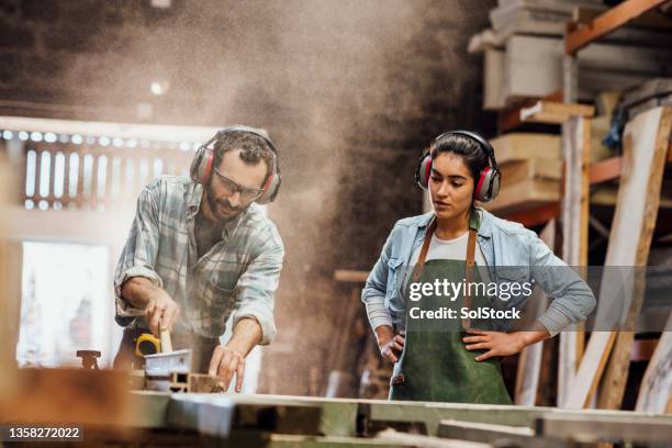 sawing wood in the workshop - ear defenders stock pictures, royalty-free photos & images