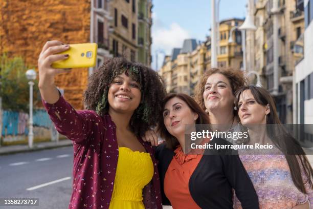 outdoor portrait of a group of female friends traveling together, multigenerational and multiethnic girls, taking a selfie - chubby granny fotografías e imágenes de stock