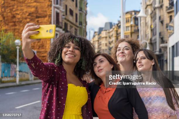 outdoor portrait of a group of female friends traveling together, multigenerational and multiethnic girls, taking a selfie - chubby granny foto e immagini stock