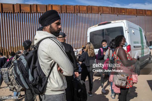 Immigrants from India and Haiti wait with others to be transported to a U.S. Border Patrol processing center on December 09, 2021 in Yuma, Arizona....