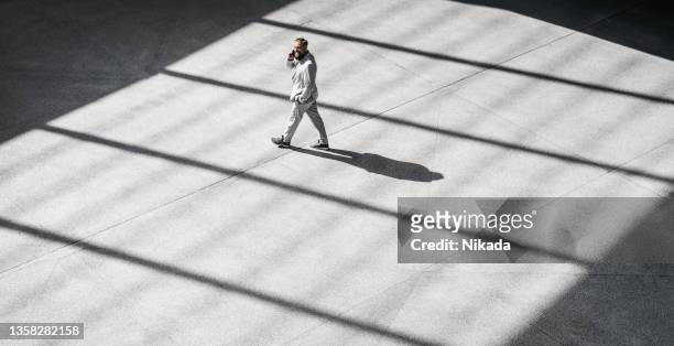 vista de ángulo alto de un hombre de negocios caminando al aire libre - centro de berlín fotografías e imágenes de stock