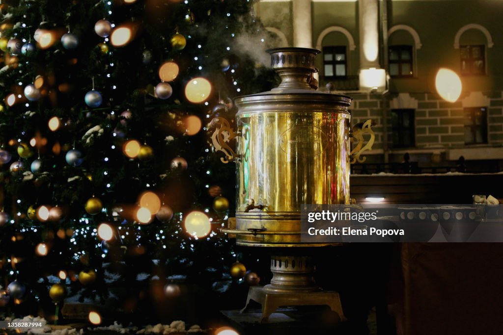 Steaming Russian Samovar Against City Street Festive Christmas Decorated