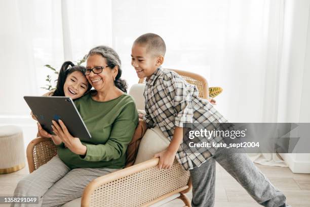 子供は祖父母のアプリを探しています - learning generation parent child ストックフォトと画像