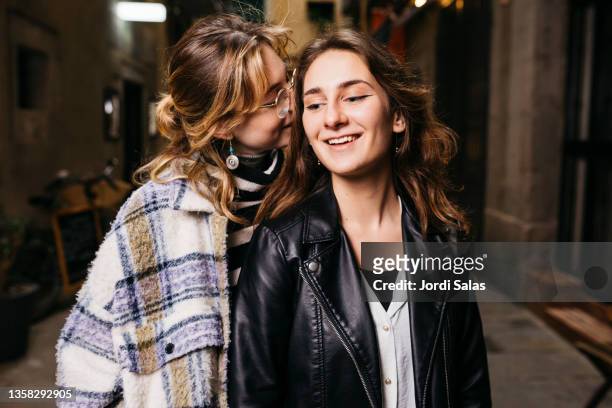 young lesbian couple on street - lesbische stockfoto's en -beelden