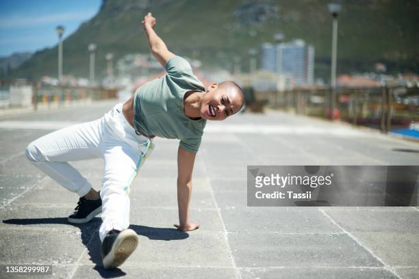 shot of a young woman dancing while out in the city - break dancer stock pictures, royalty-free photos & images
