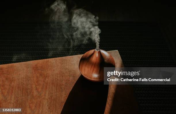 a thick mist gently rises from an oil diffuser, used in aromatherapy - wellness spa stock pictures, royalty-free photos & images