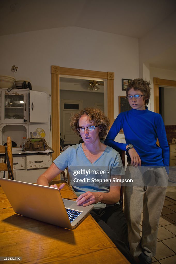Mom and son with laptop in farm house