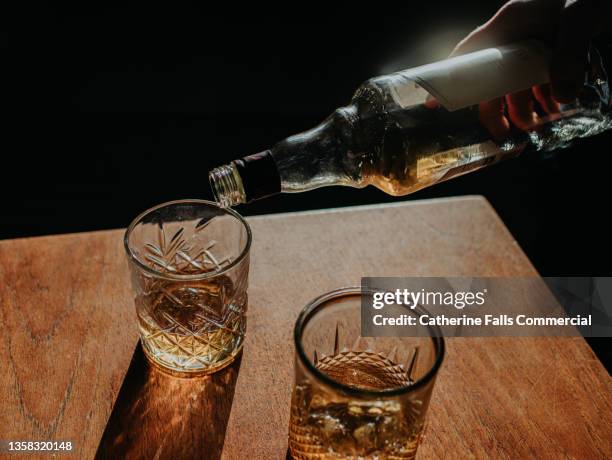 whisky pour from a bottle into a cut glass tumbler - alchol fotografías e imágenes de stock