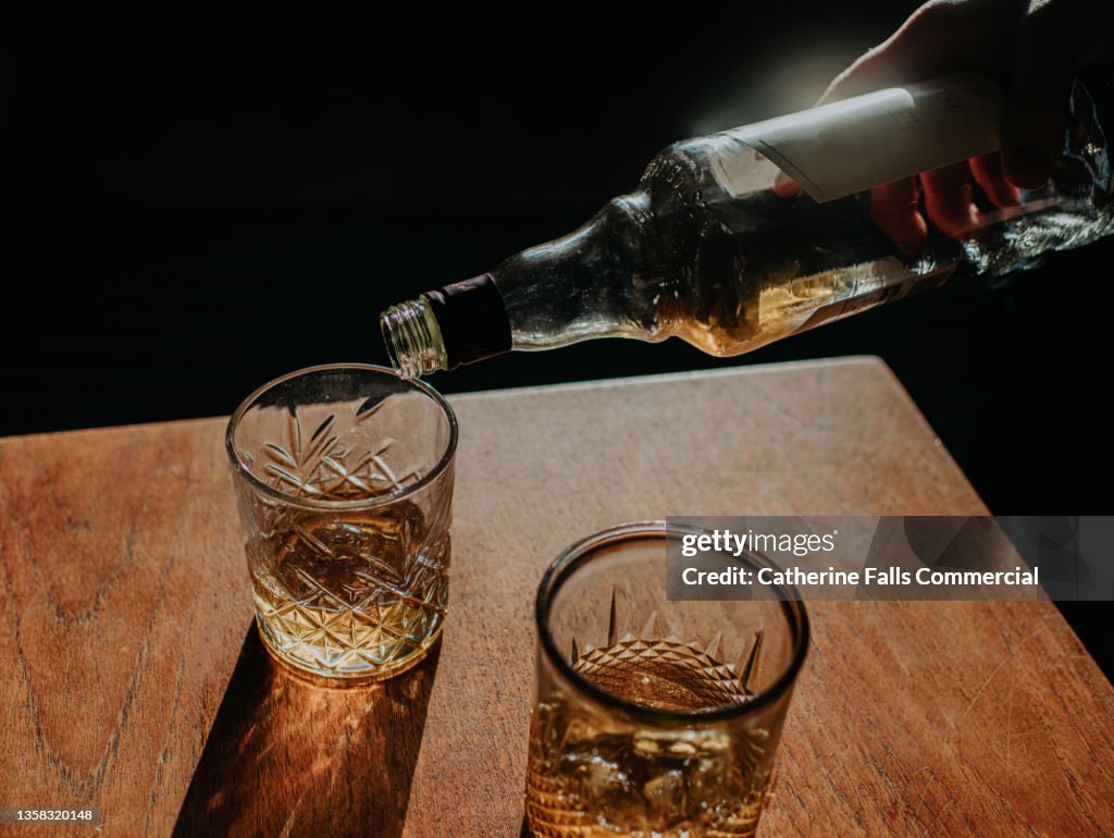 Whisky Pour from a bottle into a cut glass tumbler