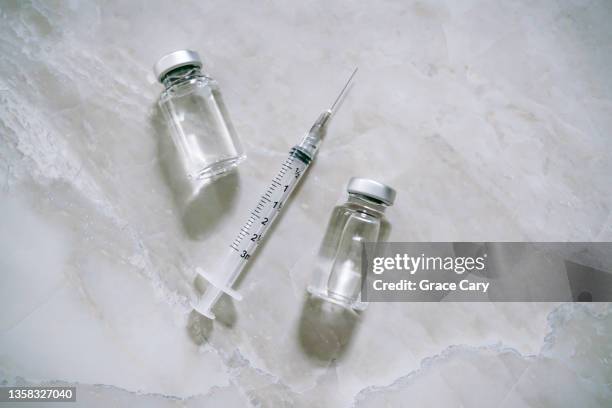 syringe with needle and medical vials filled with liquid solution - volume fluid capacity stock pictures, royalty-free photos & images