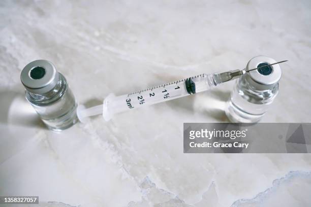 syringe with needle and medical vials filled with liquid solution - volume fluid capacity stock pictures, royalty-free photos & images