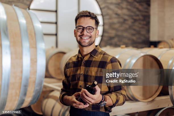 ワインセラーで働く幸せな職人の肖像 - ワイン醸造業者 ストックフォトと画像