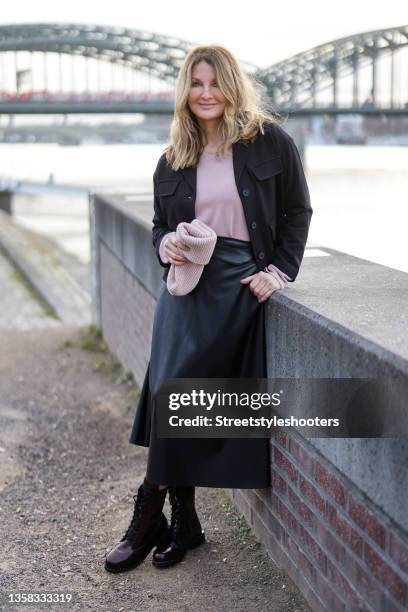 Host Frauke Ludowig wearing a mauve colored pullover by Funky Staff, a black blouse by Funky Staff, a long black leather skirt by Funky Staff, a...