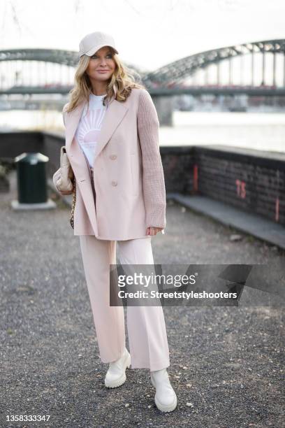 Host Frauke Ludowig wearing a pastel pink suit by Riani, a white shit with pink print by Riani, a pastel pink cap by Riani, ivory colored boots by...
