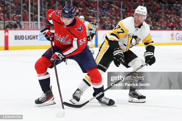 Aliaksei Protas of the Washington Capitals skates past Jeff Carter of the Pittsburgh Penguins during the third period at Capital One Arena on...