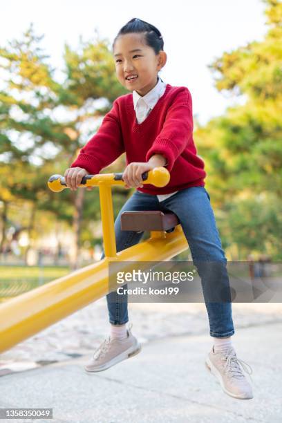 niña jugando en balancín - see saw fotografías e imágenes de stock