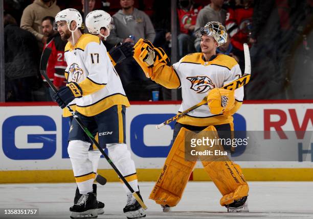 Ben Harpur, Ryan Johansen and Juuse Saros of the Nashville Predators celebrate the win over the New Jersey Devils after the game at Prudential Center...