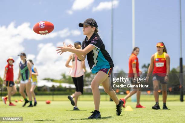 Girls passes the ball during a combined AFL Queensland / Gold Coast Suns football clinic at Metricon Stadium on December 11, 2021 in Gold Coast,...