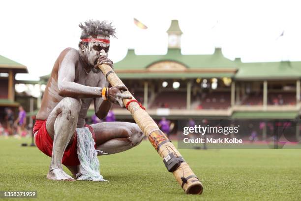 An indigenous performer plays the didgeridoo during a smoking ceremony before play in the Men's Big Bash League match between the Sydney Sixers and...