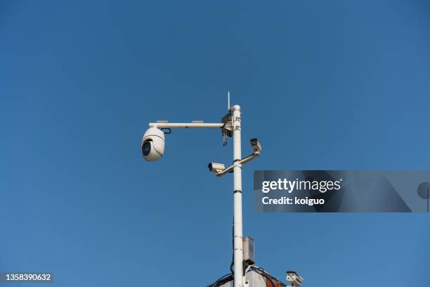 smart surveillance camera under the blue sky - camera pole stockfoto's en -beelden