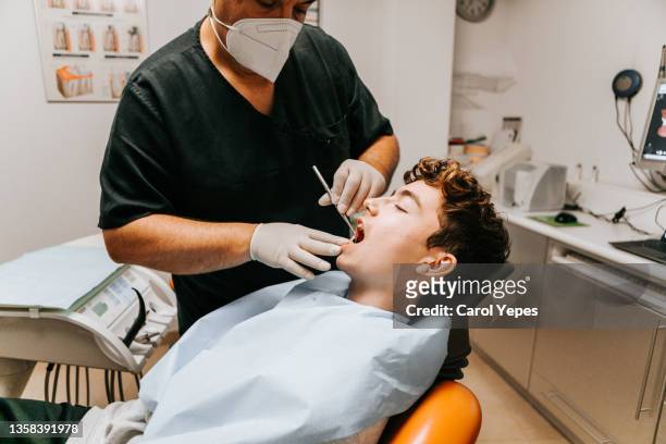 checking the teeth at the dentist office - dentists chair stock pictures, royalty-free photos & images