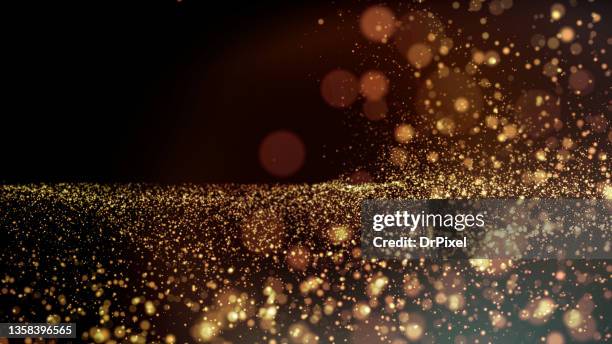 sparkling golden particles - glittering ストックフォトと画像