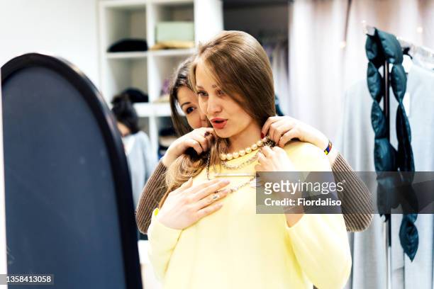 two middle-aged women pick up clothes in a boutique - jewellery designer stock pictures, royalty-free photos & images