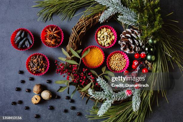 schöne flache lage mit leckeren weihnachtsgewürzen in sechs rosa muffin-backformen auf schwarzem grunge-hintergrund mit weihnachtsdekoration - wacholderbeeren stock-fotos und bilder