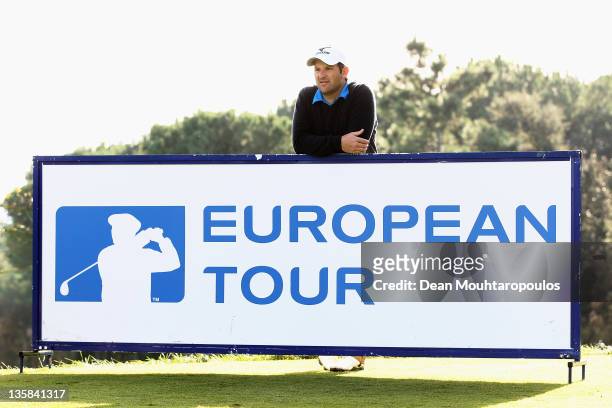 David Dixon of England leans on a European Tour sign as he looks down the 9th hole during the Final Round of the European Tour Qualifying School at...