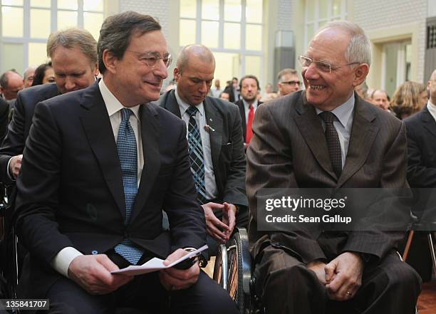 Mario Draghi , President of the European Central Bank , and German Finance Minister Wolfgang Schaeuble chat at the Ludwig Erhard Lecture on December...