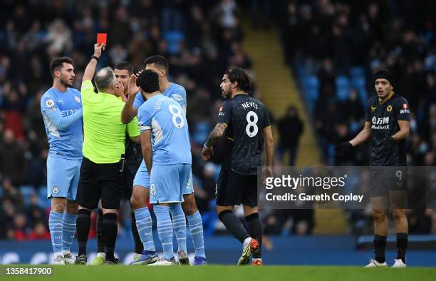 Referee, Jonathan Moss shows a red card to Raul Jimenez of Wolverhampton Wanderers during the Premier League match between Manchester City and...