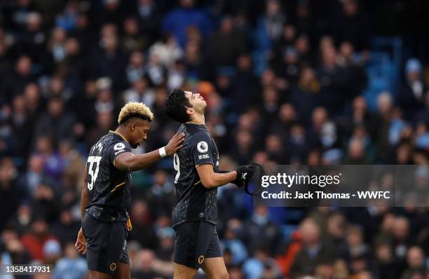 Adama Traore consoles Raul Jimenez of Wolverhampton Wanderers as he leaves the pitch after being shown a red card during the Premier League match...