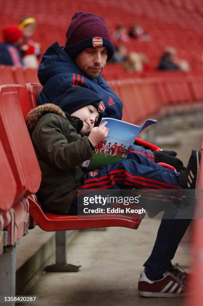 Young fan reads a match programme prior to the Premier League match between Arsenal and Southampton at Emirates Stadium on December 11, 2021 in...