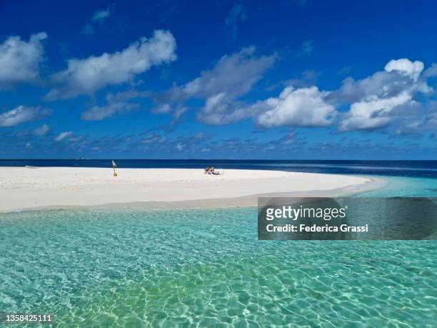 woman watching her mobile phone on a beach chair on maldivian island rannalhi - male maldives stock-fotos und bilder