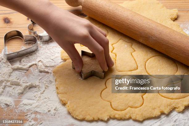 hand cutting out a cookie - moule photos et images de collection