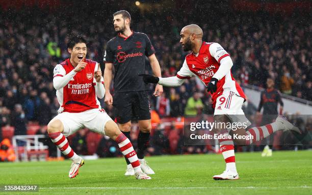 Alexandre Lacazette of Arsenal celebrates with teammate Takehiro Tomiyasu after scoring their side's first goal during the Premier League match...