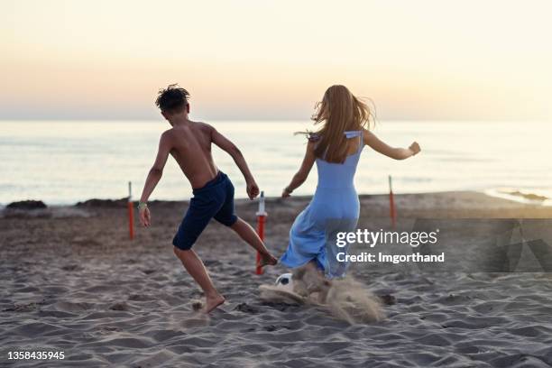 des adolescents qui jouent au soccer sur la plage - boy wearing dress photos et images de collection